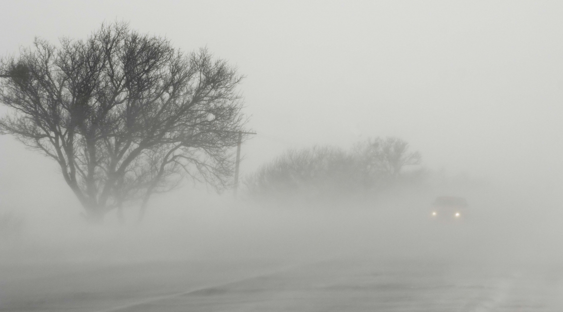 Driving in the dense fog, the visibility is severely limited. Listen and stay focused on the road.